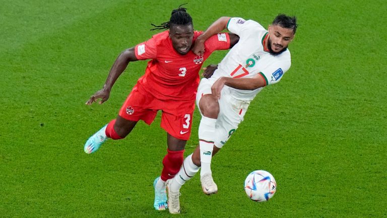 Canada's Sam Adekugbe and Morocco's Sofiane Boufal vie for the ball during the World Cup group F soccer match between Canada and Morocco at the Al Thumama Stadium in Doha , Qatar, Thursday, Dec. 1, 2022. (Alessandra Tarantino/AP)