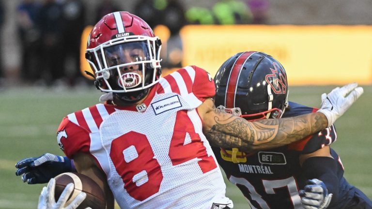 Calgary Stampeders' Reggie Begelton (84) is tackled by Montreal Alouettes' Wesley Sutton during first half CFL football action in Montreal, Sunday, July 30, 2023. (Graham Hughes/THE CANADIAN PRESS)