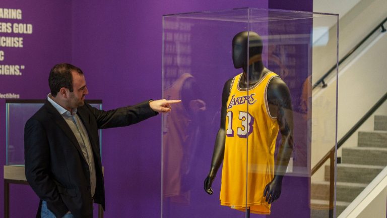 Sotheby's Vice President Brahm Wachter looks at the display of Wilt Chamberlain's 1972 NBA Finals 'Championship Clinching' Jersey at Sotheby's Los Angeles Gallery on Tuesday, Aug. 1, 2023, in Beverly Hills, Calif. The jersey is being offered along with a collection of memorabilia in an online sale Aug. 28-Sept. 27. (Damian Dovarganes/AP)