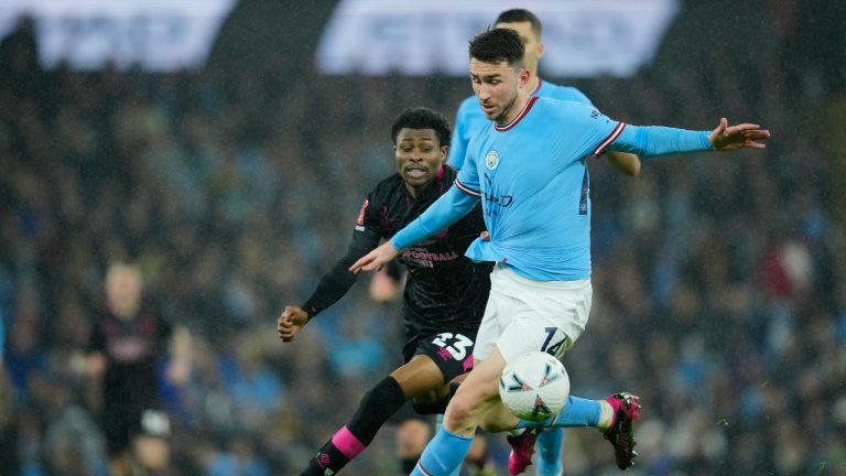 Manchester City's Aymeric Laporte, front, duels for the ball with Burnley's Nathan Tella during the English FA Cup quarter final soccer match between Manchester City and Burnley at the Etihad stadium in Manchester, England, Saturday, March 18, 2023. (Jon Super/AP)