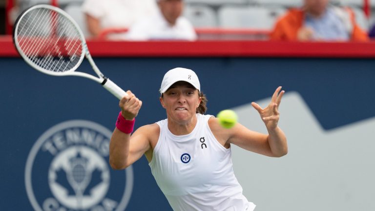 Iga Swiatek of Poland, hits a return to Danielle Collins of the United States, during quarterfinal action at the National Bank Open tennis tournament in Montreal, Friday, Aug.11, 2023. (CP)