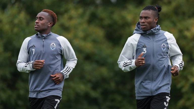 Vancouver Whitecaps' Richie Laryea, left, and Sam Adekugbe jog together during their first training session with the MLS soccer club, in Vancouver, B.C., Wednesday, Aug. 9, 2023. (Darryl Dyck/CP)