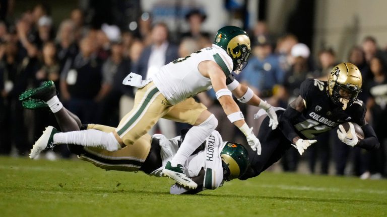 Colorado cornerback Travis Hunter (12) is dragged down after a short gain by Colorado State defensive back Henry Blackburn, back left, and defensive back Ayden Hector during the first half of an NCAA college football game Saturday, Sept. 16, 2023, in Boulder, Colo. (David Zalubowski/AP)
