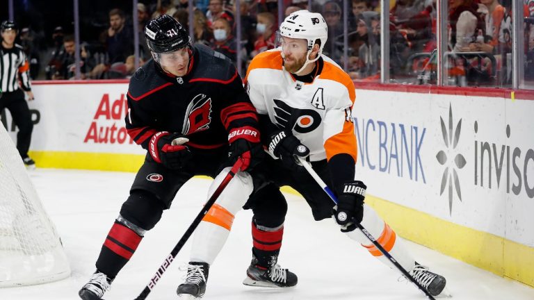 Philadelphia Flyers' Sean Couturier (14) controls the puck with Carolina Hurricanes' Jesper Fast (71) nearby during the first period of an NHL hockey game in Raleigh, N.C., Friday, Nov. 12, 2021. (Karl B DeBlaker/AP)