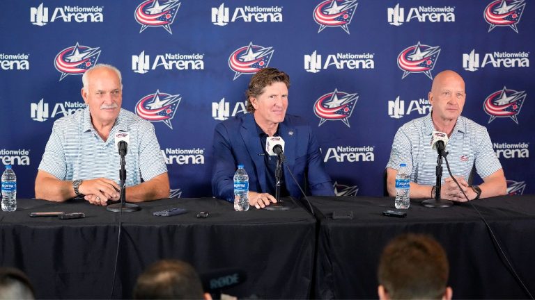 Mike Babcock sits between Columbus Blue Jackets president John Davidson, left, and GM Jarmo Kekalainen as they address the media as when introduced Babcock as their new head coach during a news conference on Saturday, July 1, 2023 in Columbus, Ohio. (Kyle Robertson/The Columbus Dispatch via AP)