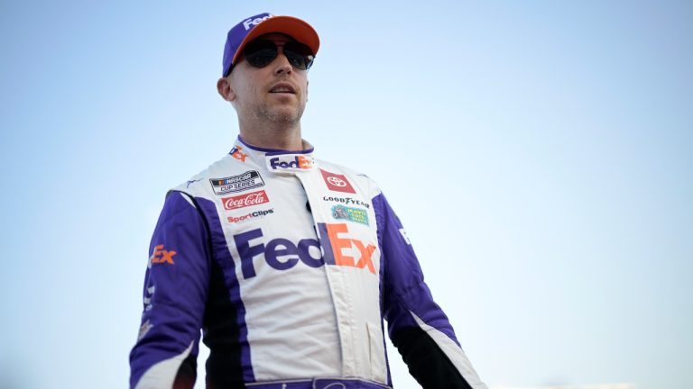 Denny Hamlin slaps hands with spectators during driver introductions before a NASCAR Cup Series auto race at Daytona International Speedway, Saturday, Aug. 26, 2023, in Daytona Beach, Fla. (Phelan M. Ebenhack/AP)