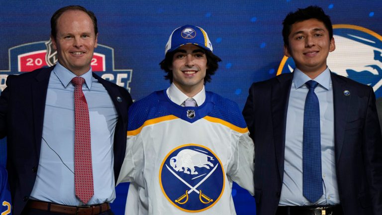Matt Savoie poses with team officials after being selected 9th by the Buffalo Sabres during the first round of the 2022 NHL Draft. (Ryan Remiorz/THE CANADIAN PRESS)