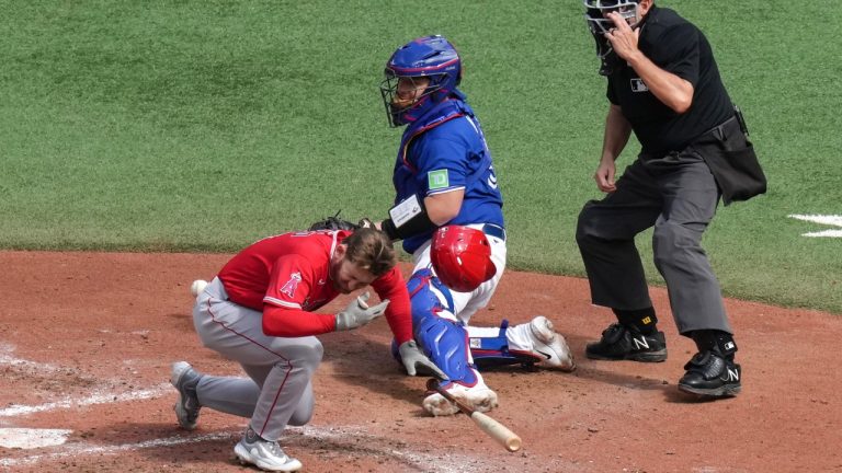 Los Angeles Angels' Taylor Ward reacts after being hit by a ball from Toronto Blue Jays starting pitcher Alek Manoah, as Blue Jays catcher Alejandro Kirk looks on during fifth inning American League MLB baseball action in Toronto on Saturday, July 29, 2023. (Chris Young/THE CANADIAN PRESS)