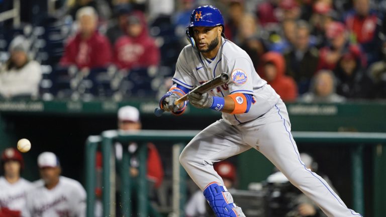 New York Mets second baseman Robinson Cano drops a bunt single against Washington Nationals starting pitcher Patrick Corbin during the fifth inning of an opening day baseball game at Nationals Park, Thursday, April 7, 2022, in Washington. (Alex Brandon/AP)