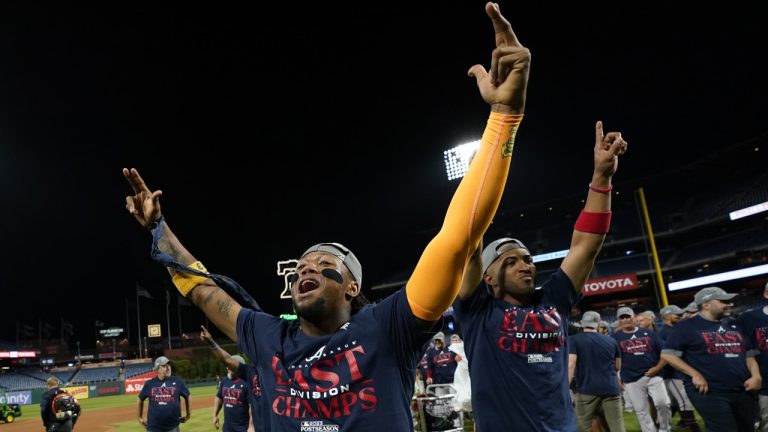 Atlanta Braves' Ronald Acuna Jr., left, and Eddie Rosario celebrate after clinching their sixth consecutive NL East title by defeating the Philadelphia Phillies in a baseball game, Wednesday, Sept. 13, 2023, in Philadelphia. (AP)