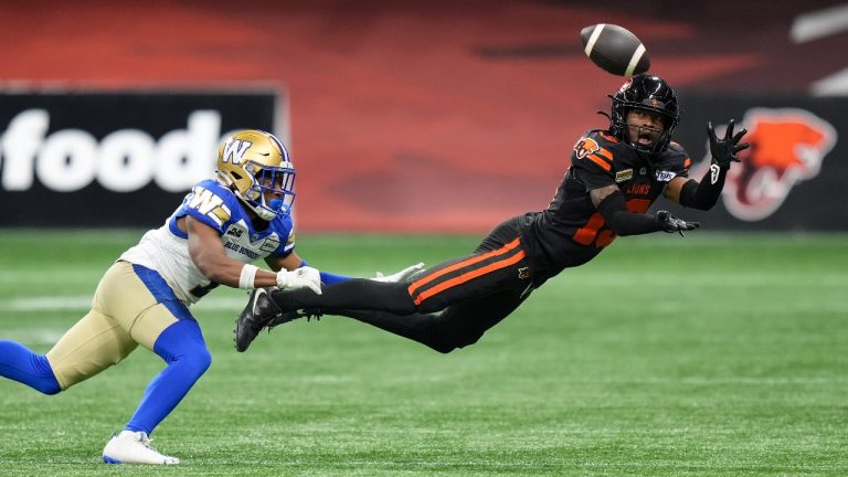 B.C. Lions' Alexander Hollins, right, makes a diving reception as Winnipeg Blue Bombers' Jamal Parker defends during the first half of a CFL football game, in Vancouver, on Friday, October 6, 2023. (CP)