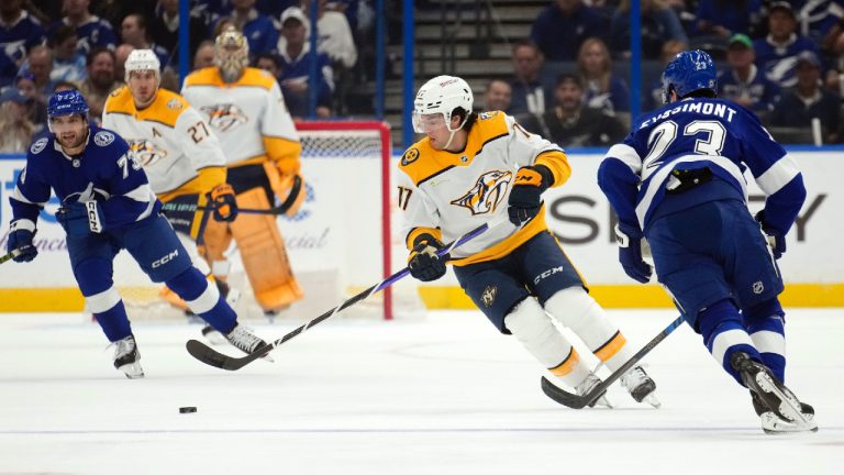 Nashville Predators centre Mark Jankowski (17) moves the puck past Tampa Bay Lightning left wing Conor Sheary (73) and center Michael Eyssimont (23) during the first period of an NHL hockey game Tuesday, Oct. 10, 2023, in Tampa, Fla. (Chris O'Meara/AP)