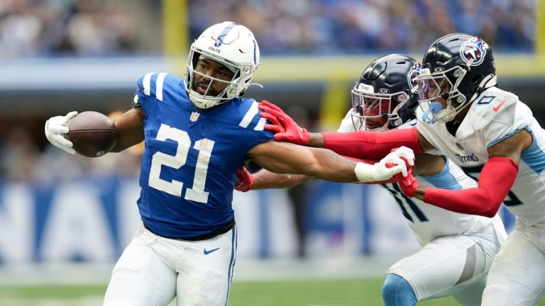 Indianapolis Colts running back Zack Moss runs past Tennessee Titans safety Kevin Byard and cornerback Sean Murphy-Bunting during the second half of an NFL football game, Sunday, Oct. 8, 2023, in Indianapolis. (Michael Conroy/AP Photo)