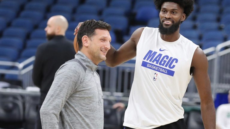 Orlando Magic forward Jonathan Isaac, right, smiles as he warms up beside assistant coach Nate Tibbetts, left, on the court before an NBA basketball game. (Stephen M. Dowell/Orlando Sentinel via AP)