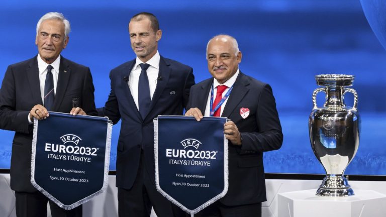 UEFA president Aleksander Ceferin, centre, shows the name of Italy and Turkey elected to host the Euro 2032 fooball tournament with Gabriele Gravina, president of the Italian Football Federation (FIGC), left, and Mehmet Buyukeksi, president of the Turkish Football Federation (TFF), right, during the the UEFA EURO 2028 and 2032 hosts announcement ceremony at UEFA Headquarters, in Nyon, Switzerland, Tuesday, October 10, 2023. (Jean-Christophe Bott/Keystone via AP)
