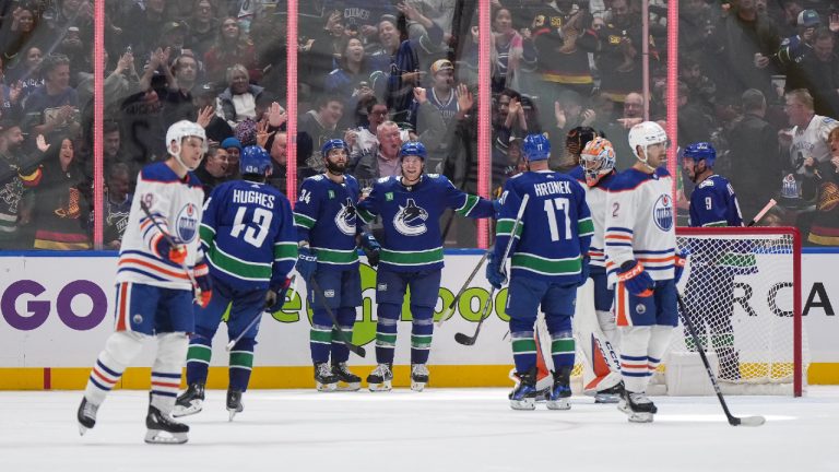Vancouver Canucks' Brock Boeser, back centre, Phillip Di Giuseppe (34), Quinn Hughes (43), Filip Hronek (17) and J.T. Miller (9) celebrate Boeser's fourth goal as Edmonton Oilers goalie Stuart Skinner, back right, Zach Hyman (18) and Evan Bouchard (2) look on, during the third period of an NHL hockey game in Vancouver, on Wednesday, October 11, 2023. (Darryl Dyck/CP)