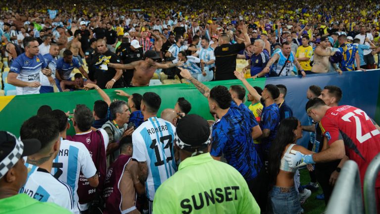 Players of Argentina try to calm the crowd after a fight between Brazilian and Argentinians fans at the stands prior to a qualifying soccer match for the FIFA World Cup 2026 at Maracana stadium in Rio de Janeiro, Brazil, Tuesday, Nov. 21, 2023. (Silvia Izquierdo/AP)