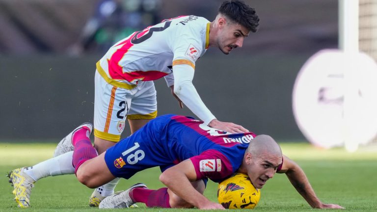 Rayo's Oscar Valentin, top, duels for the ball with Barcelona's Oriol Romeu during a Spanish La Liga soccer match between Rayo Vallecano and Barcelona at the Vallecas stadium in Madrid, Spain, Saturday, Nov. 25, 2023. (Jose Breton/AP) 
