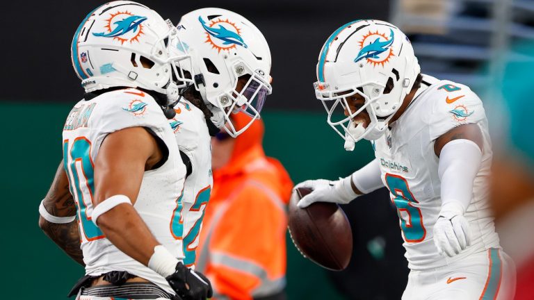 Miami Dolphins safety Jevon Holland (8) celebrates with teammates after running an interception back for a touchdown against the New York Jets during the second quarter of an NFL football game, Friday, Nov. 24, 2023, in East Rutherford, N.J. (Noah K. Murray/AP)