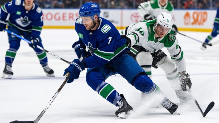 Dallas Stars' Ty Dellandrea grabs Vancouver Canucks' Carson Soucy as he skates with the puck during the first period of an NHL hockey game in Vancouver, on Saturday, Nov. 4, 2023. (Ethan Cairns/CP Photo)