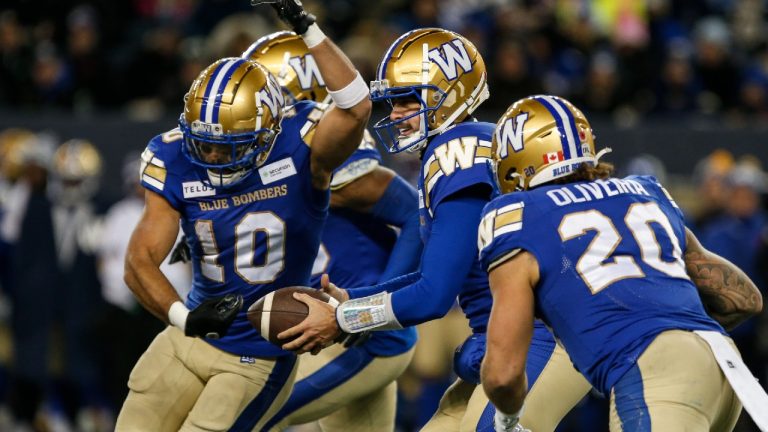 Winnipeg Blue Bombers quarterback Zach Collaros (8) fakes the handoff to Nic Demski (10) and gives it to Brady Oliveira (20) during first half CFL action against the B.C. Lions in Winnipeg Saturday, November 11, 2023. (John Woods/CP)