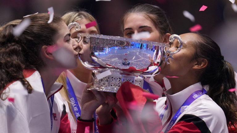 Canada's Leylah Fernandez, right, kisses the trophy with members of her team after wining the final singles tennis match against Italy's Jasmine Paolini, during the Billie Jean King Cup finals in La Cartuja stadium in Seville, southern Spain, Spain, Sunday, Nov. 12, 2023. (AP)