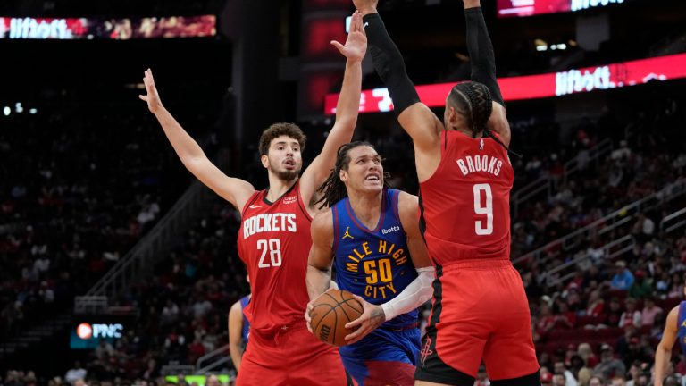 Denver Nuggets' Aaron Gordon (50) drives toward the basket as Houston Rockets' Alperen Sengun (28) and Dillon Brooks (9) defend during the first half of an NBA basketball game Sunday, Nov. 12, 2023, in Houston. (David J. Phillip/AP)