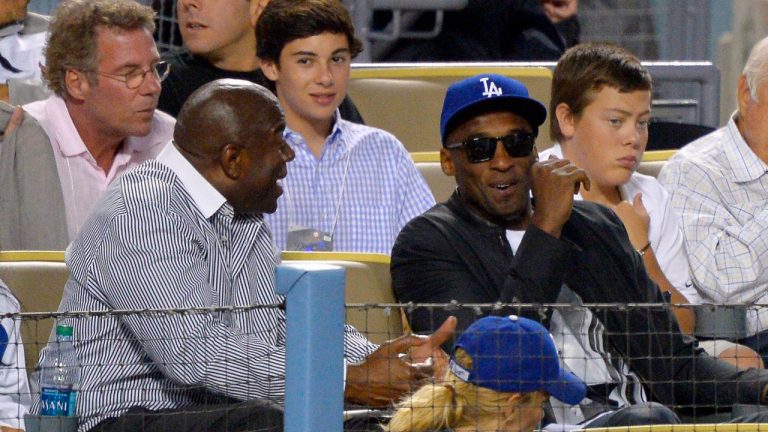Los Angeles Dodgers co-owner and former Los Angeles Laker Earvin "Magic" Johnson, left, talks with former Los Angeles Lakers guard Kobe Bryant as they watch the Dodgers play the New York Yankees in a baseball game, Wednesday, July 31, 2013, in Los Angeles. (Mark J. Terrill/AP)