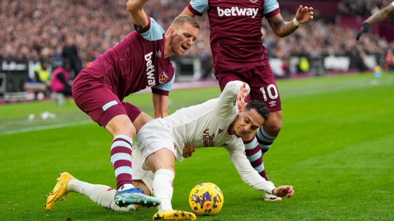 Manchester United's Antony, bottom, is challenged by West Ham's Tomas Soucek, left, during the English Premier League soccer match between West Ham United and Manchester United at the London stadium in London, Saturday, Dec. 23, 2023. (Kirsty Wigglesworth/AP)