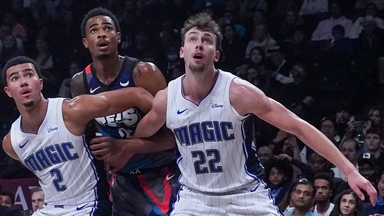 Orlando Magic's Caleb Houstan, left, and teammate Franz Wagner, right, blocks Brooklyn Nets' Nic Claxton, center. (Bebeto Matthews/AP)