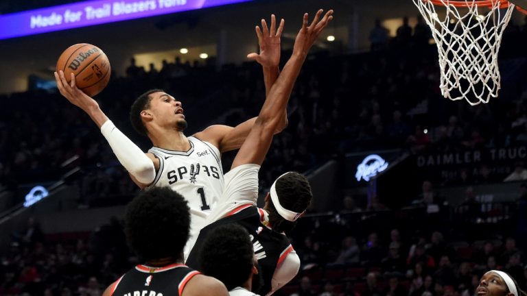 San Antonio Spurs center Victor Wembanyama, left, drives to the basket against Portland Trail Blazers center Moses Brown, center, as forward Jerami Grant, right, watches during the first half of an NBA basketball game in Portland, Ore., Thursday, Dec. 28, 2023. (Steve Dykes/AP)