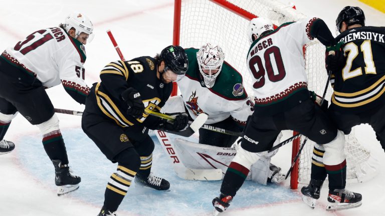 Boston Bruins' Pavel Zacha (18) battles Arizona Coyotes' J.J. Moser (90) and Troy Stecher (51) for control of the puck in front of goalie Connor Ingram during the first period of an NHL hockey game, Saturday, Dec. 9 2023, in Boston. (Michael Dwyer/AP)