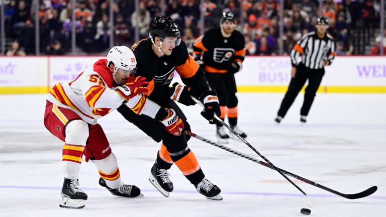 Calgary Flames' MacKenzie Weegar, left, and Philadelphia Flyers' Travis Sanheim battle for the puck during the second period of an NHL hockey game, Monday, Nov. 21, 2022, in Philadelphia. (Derik Hamilton/AP)