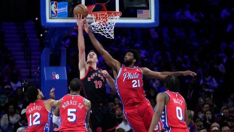 Toronto Raptors' Jakob Poeltl (19) goes up for a shot against Philadelphia 76ers' Joel Embiid (21) during the first half of an NBA basketball game, Friday, Dec. 22, 2023, in Philadelphia. (Matt Slocum/AP)