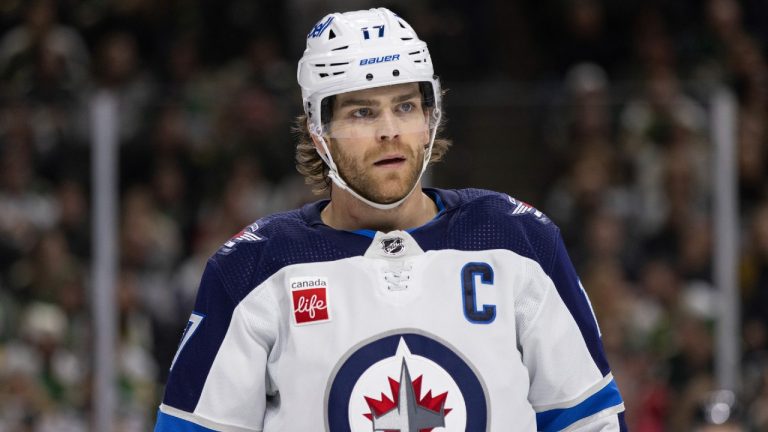 Winnipeg Jets captain Adam Lowry (17) looks on before a face-off against the Minnesota Wild during the first period of an NHL hockey game Sunday, Dec. 31, 2023, in St. Paul, Minn. (Bailey Hillesheim/AP)
