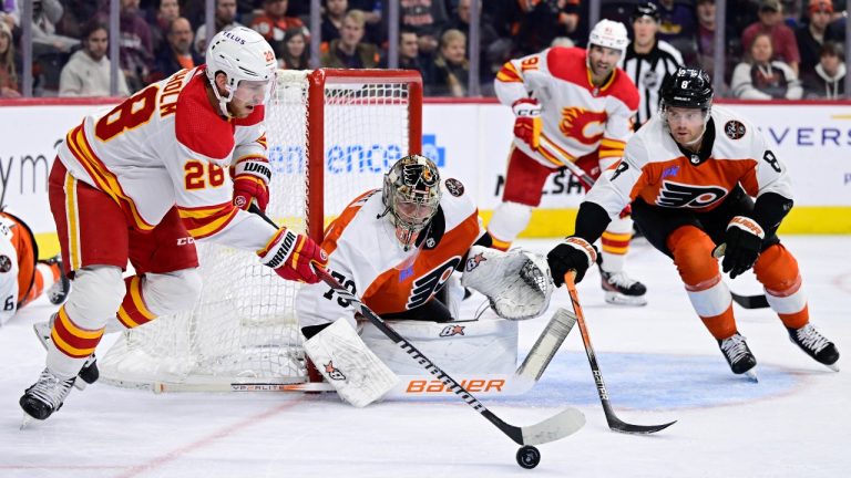 Philadelphia Flyers goaltender Carter Hart, centre, and Cam York (8) defend a shot from Calgary Flames' Elias Lindholm, left, during the first period of an NHL hockey game, Saturday, Jan. 6, 2024, in Philadelphia. (AP)