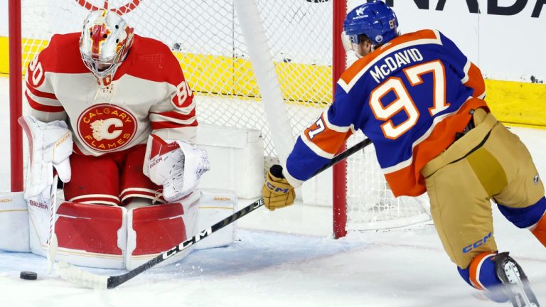 Edmonton Oilers' Connor McDavid, right, has a shot stopped by Calgary Flames goalie Dan Vladar during first period NHL hockey action in Calgary, Saturday, Jan. 20, 2024. (Larry MacDougal/CP)