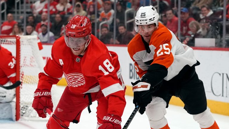 Detroit Red Wings center Andrew Copp (18) and Philadelphia Flyers center Ryan Poehling (25) reach for the puck during the first period of an NHL hockey game, Thursday, Jan. 25, 2024, in Detroit. (AP/Carlos Osorio)