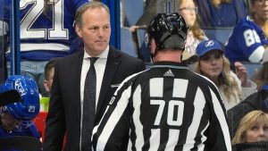 Tampa Bay Lightning head coach Jon Cooper talks to linesman Derek Nansen (70) during the third period of an NHL hockey game against the Los Angeles Kings Tuesday, Jan. 9, 2024, in Tampa, Fla. Cooper picked up his 500th win in the Lightning's 3-2 overtime victory. (Chris O'Meara/AP)