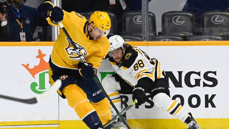 Nashville Predators defenceman Kevin Gravel (5) gets control of the puck in front of Boston Bruins right wing David Pastrnak (88) during the third period of an NHL hockey game Thursday, Feb.16, 2023, in Nashville, Tenn. (Mark Zaleski/AP)