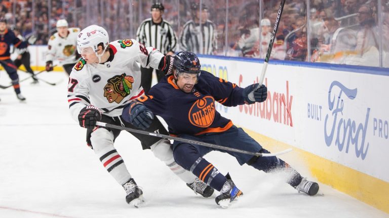 Chicago Blackhawks' Lukas Reichel (27) looks for the puck against Edmonton Oilers' Cody Ceci (5) during first period NHL hockey action in Edmonton, Thursday, Jan. 25, 2024. (Amber Bracken/CP)