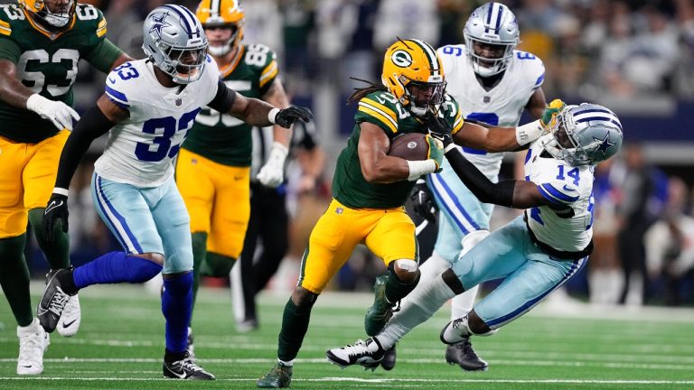 Green Bay Packers running back Aaron Jones (33) applies a stiff-arm on Dallas Cowboys safety Markquese Bell (14) while rushing for yardage during the first half of an NFL football game, Sunday, Jan. 14, 2024, in Arlington, Texas. (Sam Hodde/AP)