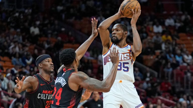 Phoenix Suns forward Kevin Durant (35) looks for an opening past Miami Heat forwards Jimmy Butler, left, and Haywood Highsmith (24) during the first half of an NBA basketball game, Monday, Jan. 29, 2024, in Miami. (AP/Wilfredo Lee)