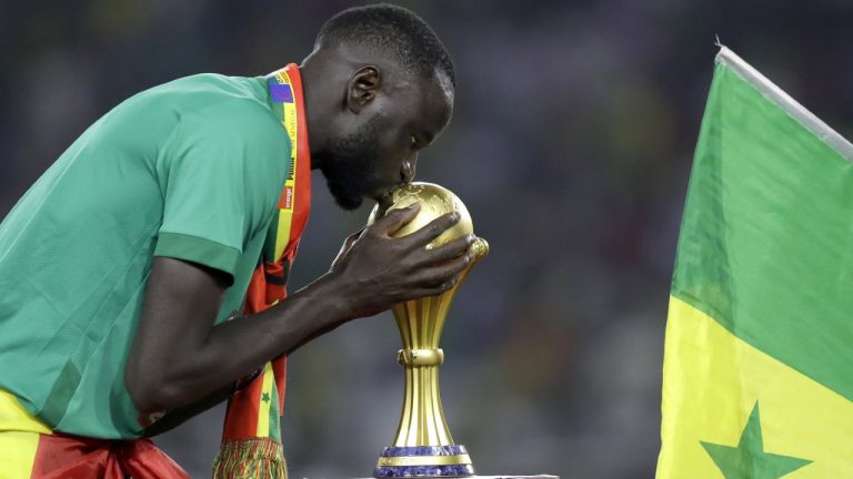Senegal's Cheikhou Kouyate kisses trophy after winning the African Cup of Nations 2022 final soccer match between Senegal and Egypt at the Ahmadou Ahidjo stadium in Yaounde, Cameroon, on Feb. 6, 2022. (Sunday Alamba/AP)