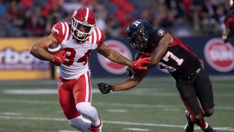Calgary Stampeders wide receiver Reggie Begelton, left, breaks free of a tackle from Ottawa Redblacks defensive back Brandin Dandridge during first half CFL action, Thursday, June 15, 2023 in Ottawa. (Adrian Wyld/CP)