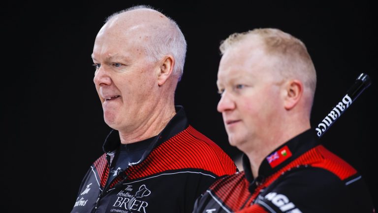 Team Ontario skip Glenn Howard, left, and third Scott Howard discuss strategy while playing Team Saskatchewan at the Tim Hortons Brier in Lethbridge, Alta., Tuesday, March 8, 2022. (Jeff McIntosh/CP)