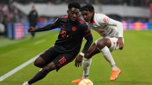 Bayern's Alphonso Davies, left, challenges for the ball with Leipzig's Mohamed Simakan during the German Bundesliga soccer match between RB Leipzig and FC Bayern Munich at the Red Bull Arena in Leipzig, Germany, Jan. 20, 2023. (Matthias Schrader/AP)