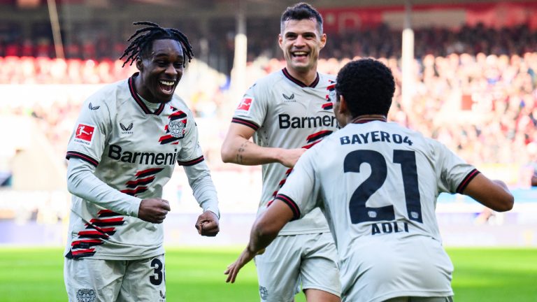 Leverkusen's Jeremie Frimpong, left, celebrates after scoring the opening goal during the Bundesliga soccer match between 1. FC Heidenheim and Bayer 04 Leverkusen in Heidenheim, Germany, Saturday, Feb. 17, 2024. (Tom Weller/dpa via AP)