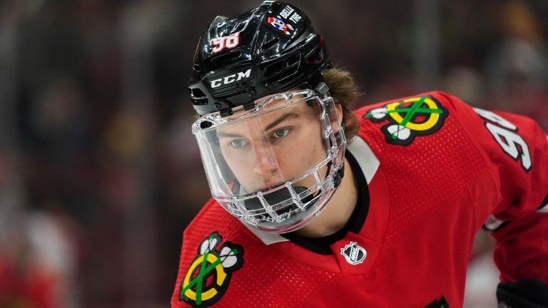 Returning from a jaw injury, Chicago Blackhawks center Connor Bedard wears a face mask during warmups before the team's NHL hockey game against the Pittsburgh Penguins, Thursday, Feb. 15, 2024, in Chicago. (Erin Hooley/AP)