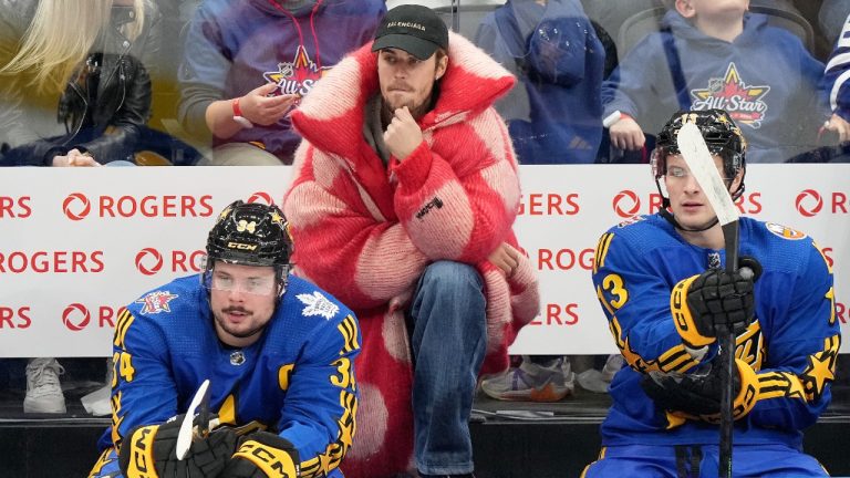 Performer Justin Bieber looks on from the bench alongside NHL All-Star Team Matthews Captain, forward Auston Matthews (34), of the Toronto Maple Leafs, and teammate Mathew Barzal (13), of the New York Islanders, during the NHL All-Star Game. (Nathan Denette/CP)